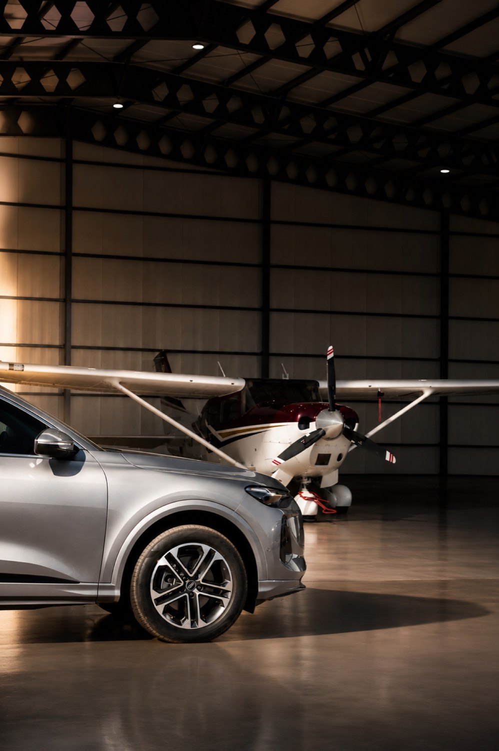 Auto estacionado junto al Cessna dentro del hangar